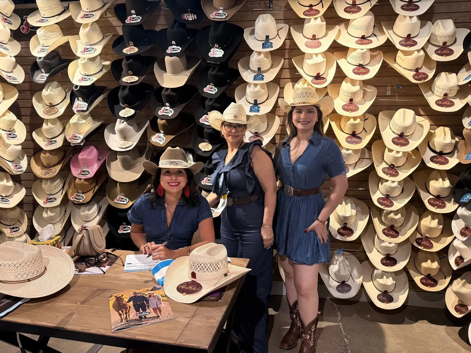 Equipo durante WESA Show frente a una exhibición de sombreros